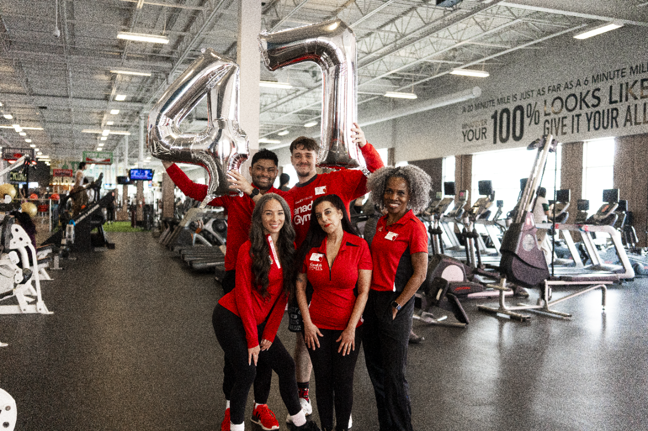 A group of GoodLife Associates holding 45lbs weights inside a club.