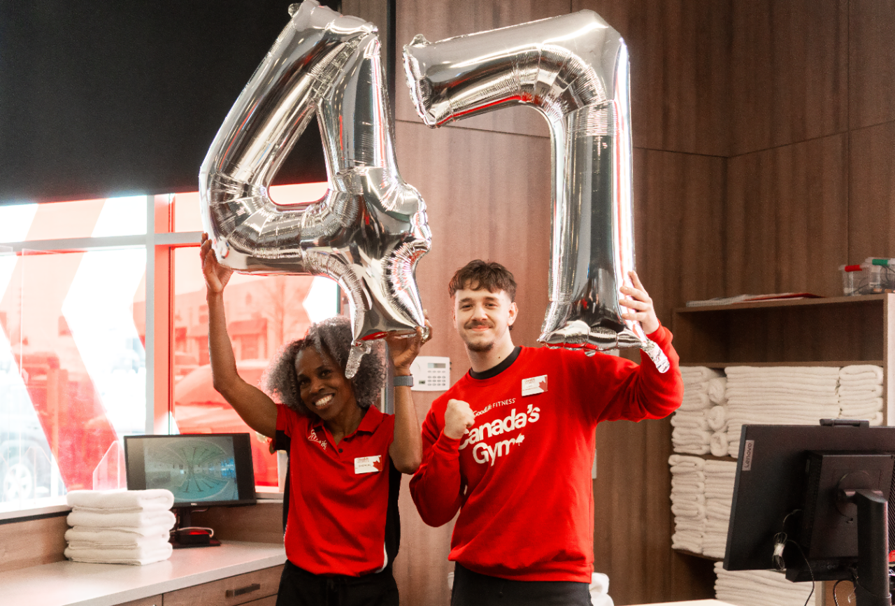 A group of GoodLife Associates holding 45lbs weights inside a club.