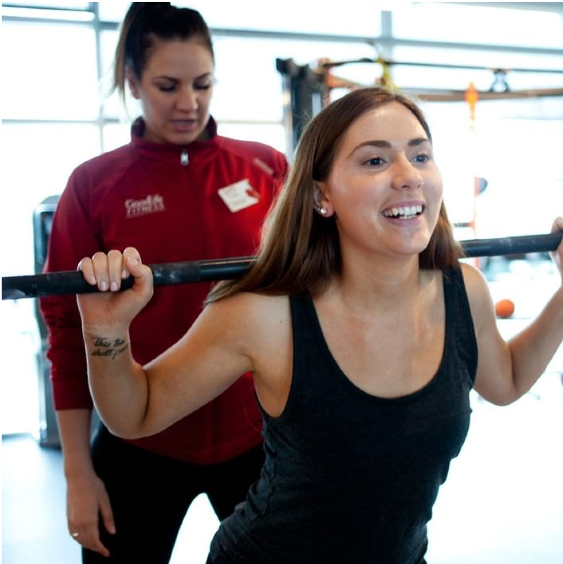 GoodLife trainer observes client’s barbell squat form