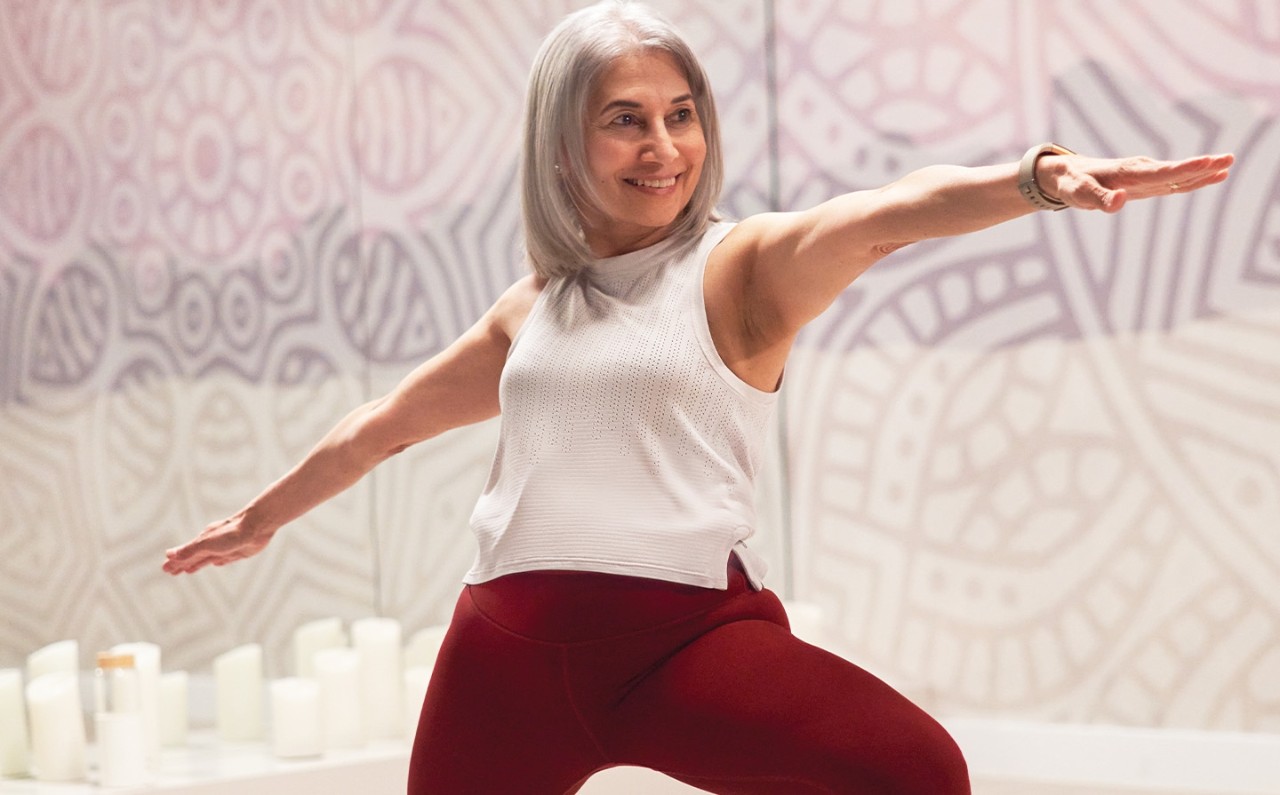 A member stands in yoga pose inside a GoodLife Fitness Yoga studio.