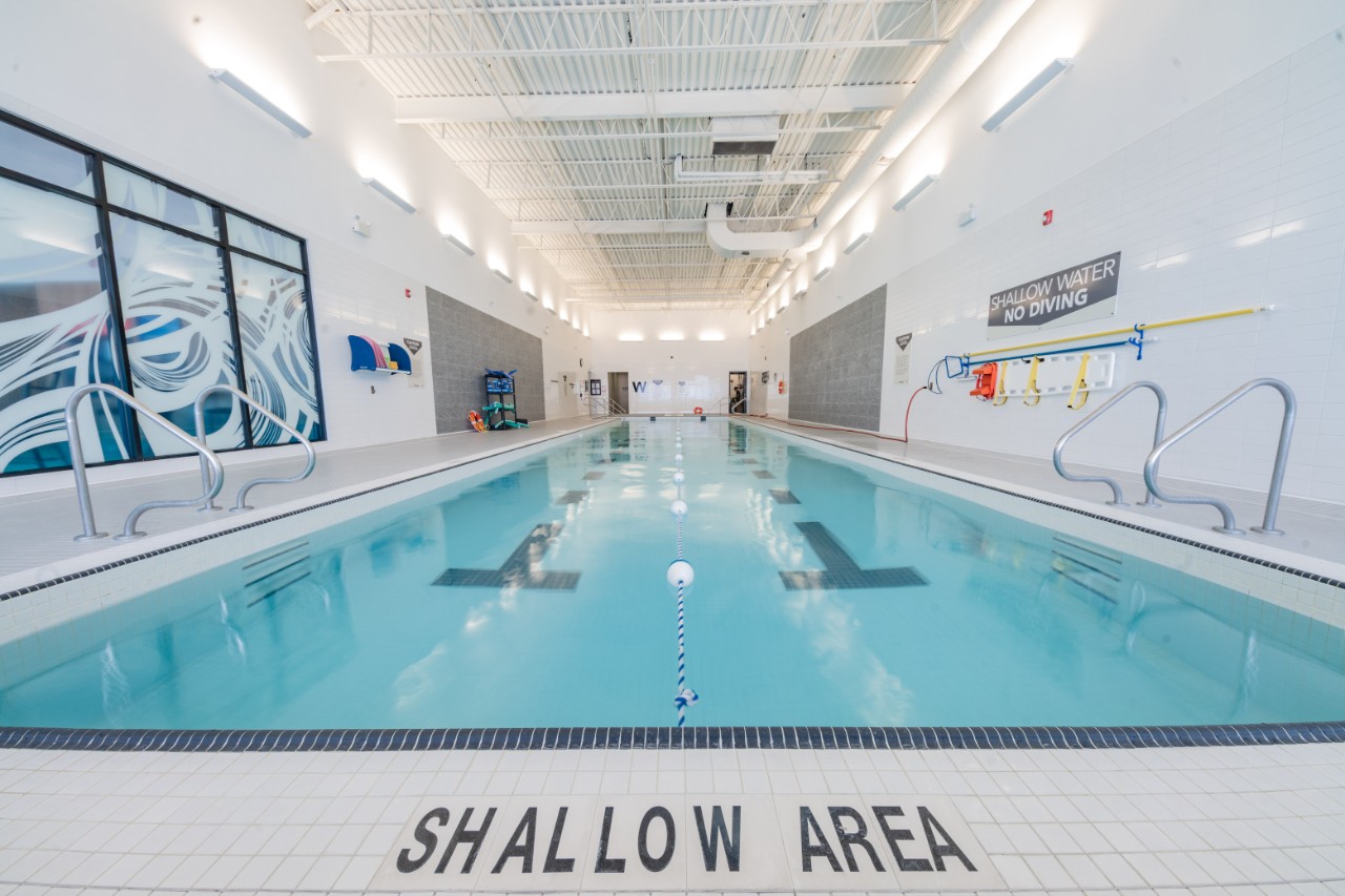 A well-lit, empty swimming pool in a GoodLife club