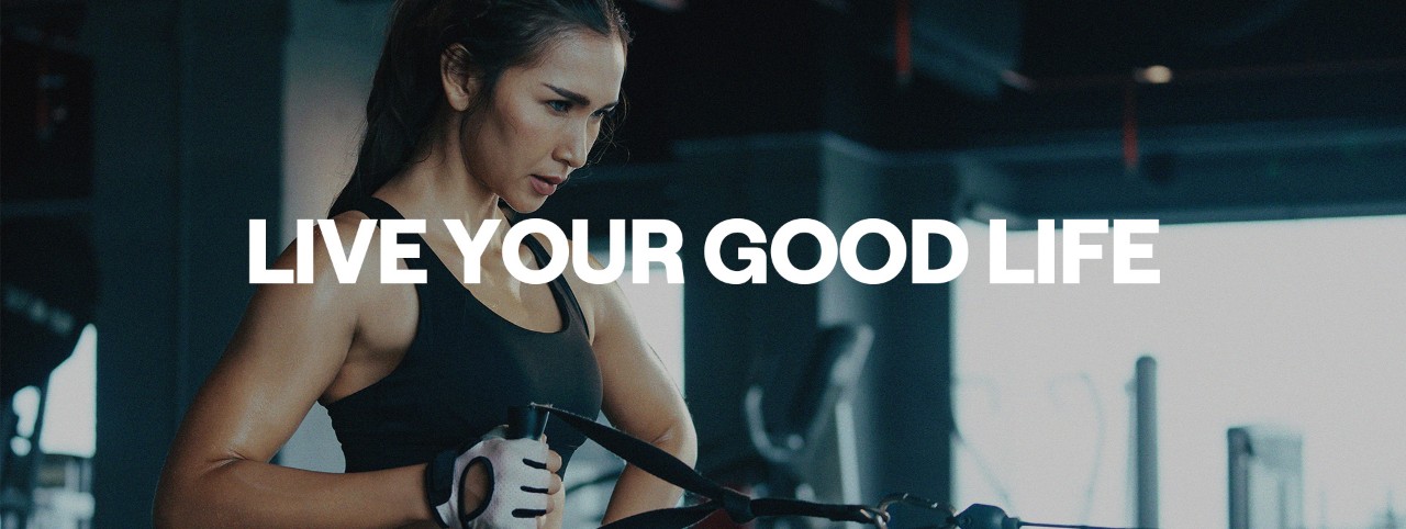 A GoodLife Fitness member standing and pulling a weight machine handle with her right arm.