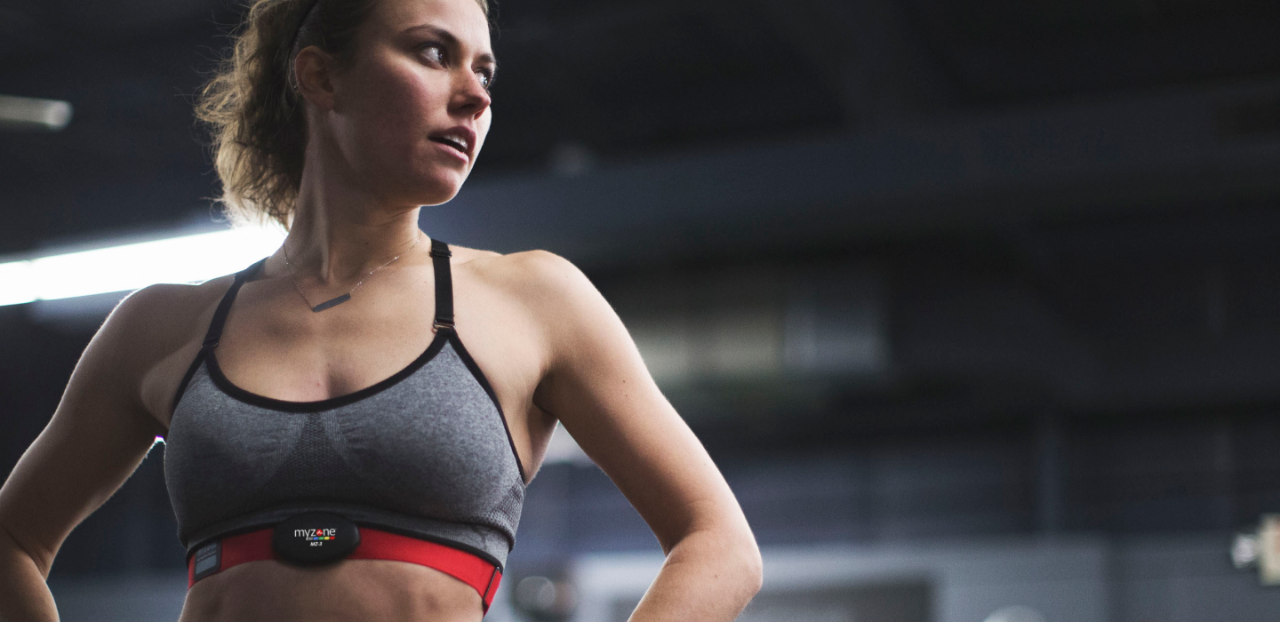 Woman standing with arms bent and wearing MYZONE, looking to the right