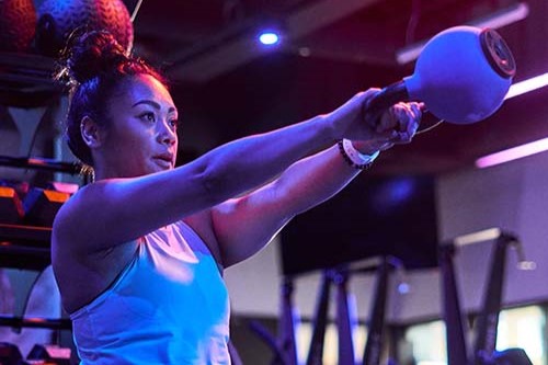 Man with boxing gloves punching a speed bag.