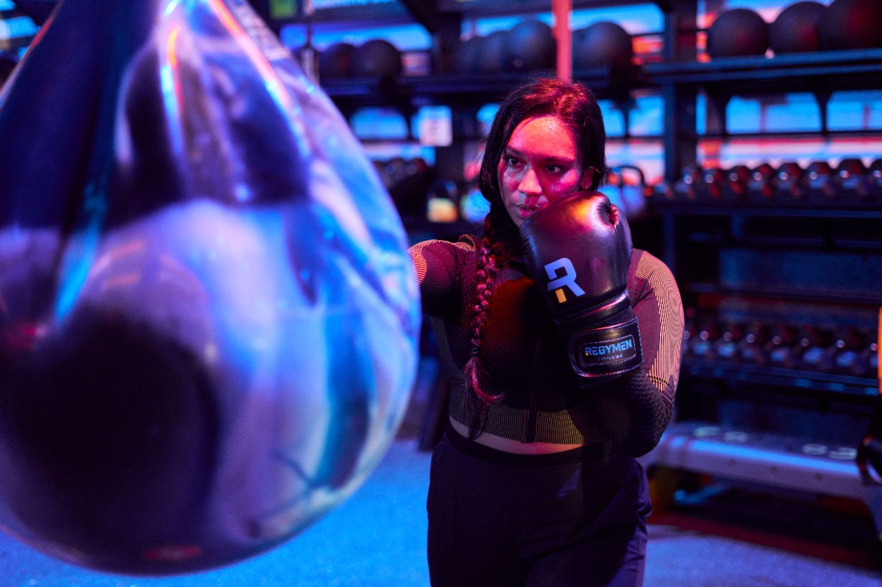 Man with boxing gloves punching a speed bag.