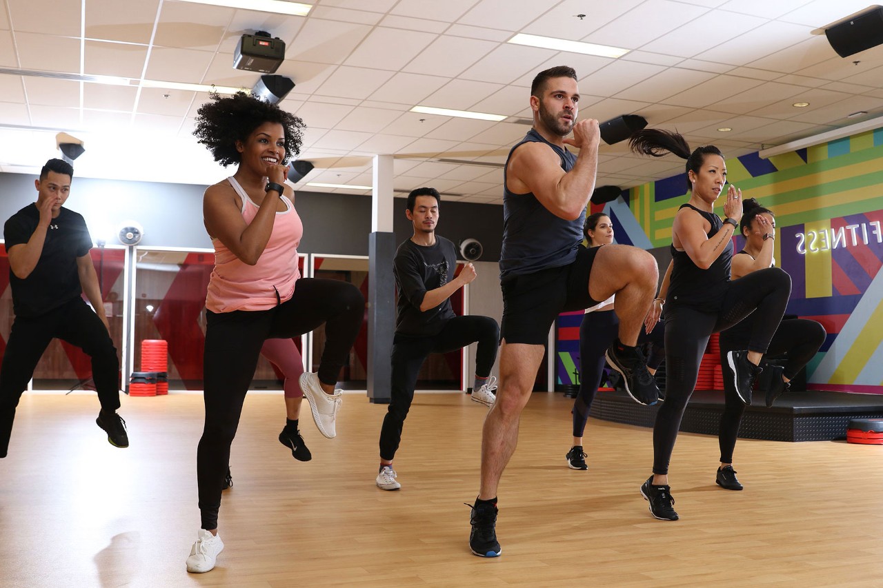 Group of seven men and women in a high-energy fitness class 