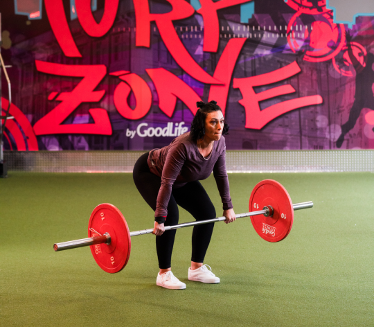 Woman squatting and lifting heavy barbells